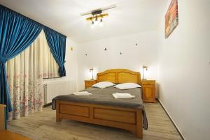 Un dormitorio con una cama y una cortina azul. en Apartament Diandru, en Slănic-Moldova