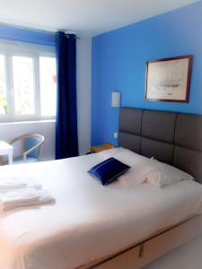 a hotel room with a large bed and a large window at Hotel La Voilerie Cancale bord de mer in Cancale