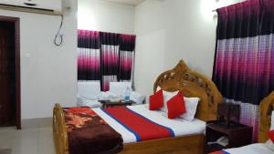 a bedroom with a bed with red and blue at Hotel Hill View in Bāndarban