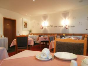 a restaurant with tables and chairs and a sign on the wall at Hotel Pension Treppengasse Nr. 5 in Altenburg