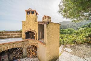 a large brick oven with a pile of fire wood at Cottage Casa Gina - Goelba in Capoliveri