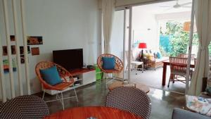 a living room with wicker chairs and a television at Villa Ximun in Roches Noires