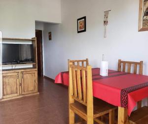 a dining room with a table with a red table cloth at Cabañas Las Pencas in Mina Clavero