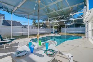 a patio with a table and chairs and a pool at Quiet Home With Private Pool- Near Disney in Kissimmee