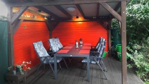una mesa y sillas en una terraza con una pared roja en Ferienwohnung Stuermer en Nordhausen