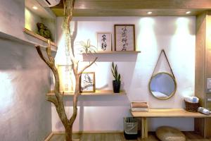 um quarto com uma árvore e prateleiras e um espelho em 唯識禪居-訂房後需聯繫轉帳 em Tainan