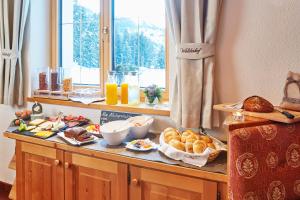 una mesa de desayuno con pan y bollería. en Gasthof Walderhof en Oetz