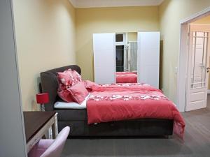 een slaapkamer met een bed met rode lakens en een spiegel bij Villa Rosali Boutique Hotel in Hamburg