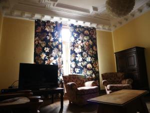 a living room with a large window with a floral curtain at Le nichoir d’hirondelles in Tintigny