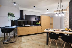 kuchnia i jadalnia ze stołem i krzesłami w obiekcie VIP Apartamenty, ORKANA APART w Zakopanem