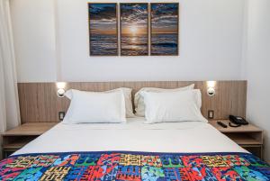 a bedroom with a large bed with two pillows at AnnA Suites Ipanema in Rio de Janeiro