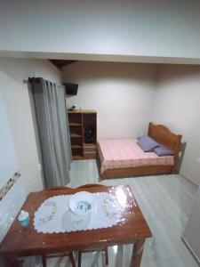 um pequeno quarto com duas camas e uma mesa em Residencial Pérola - Localizado entre a Pinheira e a Guarda do Embaú em Guarda do Embaú