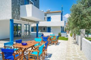 a patio with wooden tables and blue chairs at Mikres Kyklades in Skala Potamias