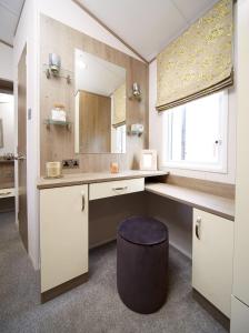 La salle de bains est pourvue d'un lavabo et d'un miroir. dans l'établissement Lavender Lodge, à South Cerney