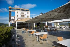 a patio area with tables, chairs and umbrellas at B&B Hotel Sado Setúbal in Setúbal