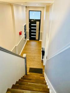 a hallway with a staircase with a black door at ND Hotels & Apartments Krefeld Zentrum in Krefeld