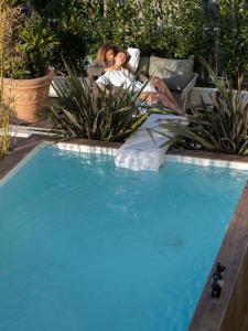 two women laying on a chair next to a swimming pool at NelBlu in Polignano a Mare