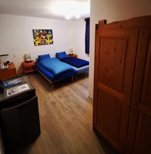 a living room with a blue couch and a bed at Sunshine in Saas-Grund