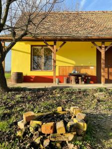 ein gelbes Haus mit einem Stapel Ziegelsteine davor in der Unterkunft Het Hongaarse Wijnhuis in Mohács