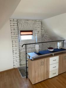 eine Küche mit einer Theke und einer Ziegelwand in der Unterkunft Het Hongaarse Wijnhuis in Mohács