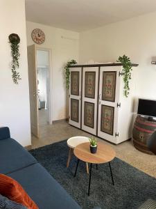 ein Wohnzimmer mit einem blauen Sofa und einem Tisch in der Unterkunft Het Hongaarse Wijnhuis in Mohács
