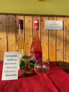 two bottles of wine and a glass on a table at Het Hongaarse Wijnhuis in Mohács