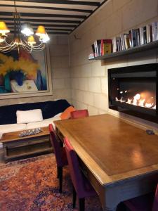ein Wohnzimmer mit einem Tisch und einem Kamin in der Unterkunft Le Baptistère - Adults only in Attichy