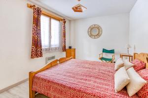 ein Schlafzimmer mit einem roten Bett und einem Fenster in der Unterkunft Les Fauvettes - appartement vue imprenable sur montagne in Embrun