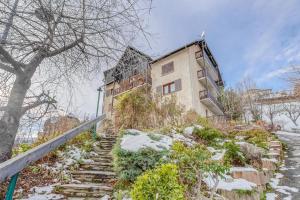 ein Gebäude auf einem Hügel mit Schnee auf der Treppe in der Unterkunft Les Fauvettes - appartement vue imprenable sur montagne in Embrun
