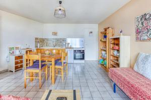 Les Fauvettes - appartement vue imprenable sur montagne في إمبرون: مطبخ وغرفة معيشة مع طاولة وكراسي