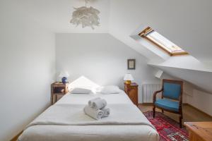 een slaapkamer met 2 bedden en een blauwe stoel bij Sotto Le Stelle - Fabuleux duplex d'hyper centre in Rennes