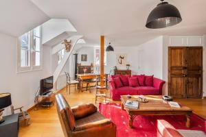 een woonkamer met een rode bank en een tafel bij Sotto Le Stelle - Fabuleux duplex d'hyper centre in Rennes