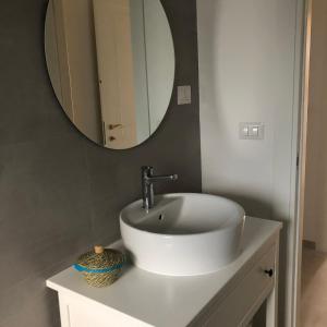 La salle de bains est pourvue d'un lavabo blanc et d'un miroir. dans l'établissement Tenuta Il Sogno, à Bénévent