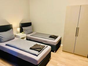 een kamer met twee bedden en een kast erin bij ND Hotels & Apartments Krefeld Zentrum in Krefeld