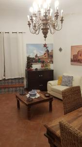 a living room with a couch and a chandelier at Casa del Parlamento in Palermo