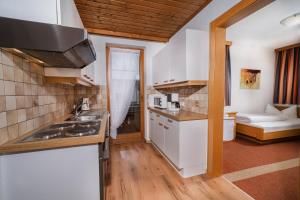 Il comprend un salon et une cuisine équipée d'appareils électroménagers blancs. dans l'établissement Landhaus Sailer, à Kappl 42 autres photos
