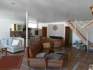 a living room with a couch and a staircase at Ferienwohnung Quelle in Friesenheim