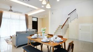 迪沙魯的住宿－Desaru Exclusive Elegant theme by Joyfully 2M8，客厅配有桌椅和沙发