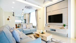 a living room with a blue couch and a tv at Desaru Exclusive Elegant theme by Joyfully 2M8 in Desaru