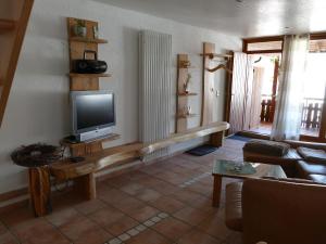 a living room with a television on a wooden shelf at Ferienwohnung Quelle in Friesenheim