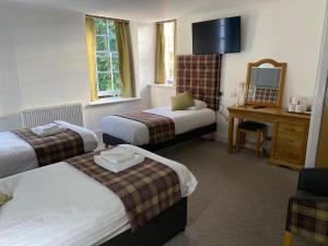 a hotel room with two beds and a mirror at Royal Dunkeld Hotel in Dunkeld
