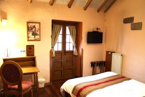 a bedroom with a bed and a desk and a window at Hotel & Mirador Los Apus in Cusco