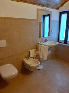 y baño con aseo, bidet y lavamanos. en Alloggi Il Rododendro, en Bagni di Vinadio