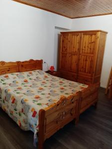 1 dormitorio con cama de madera y armarios de madera en Alloggi Il Rododendro, en Bagni di Vinadio