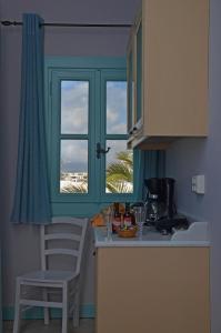 uma cozinha com uma janela e uma mesa com cadeiras em Villa Ostria em Koufonisia
