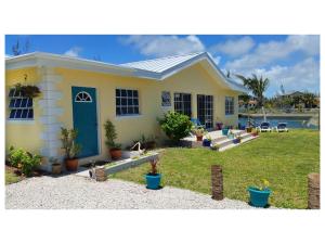 a yellow house with a yard and a pool at Silver Point Villa in Freeport