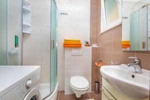 a bathroom with a toilet and a sink and a shower at Apartment Una in Cavtat +19 photos