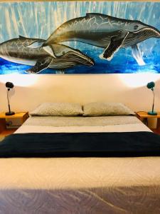 Schlafzimmer mit einem Bett mit Wandgemälde in der Unterkunft Hotel Posada Señor Mañana in San José del Cabo
