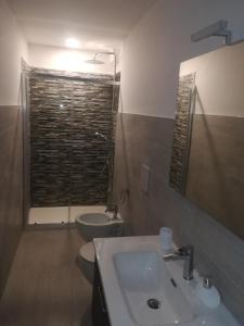 uma casa de banho com um lavatório, um WC e um espelho. em B&B Il RE em Castellaneta