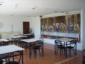 a room with tables and a painting on the wall at Il Giardino delle Esperidi in Fosdinovo